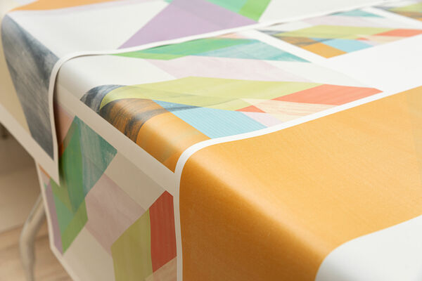 Customized colourful wallcovering laid out over a table