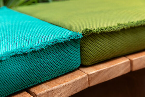 close up of two upholstered cushions in mossy and grassy shades