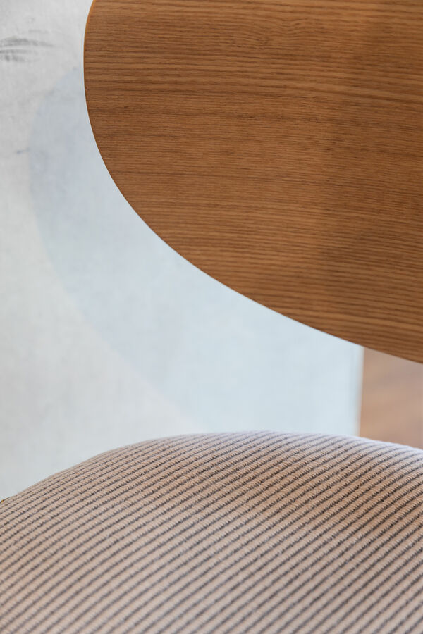 close up of a chair with upholstered seating and wooden backrest